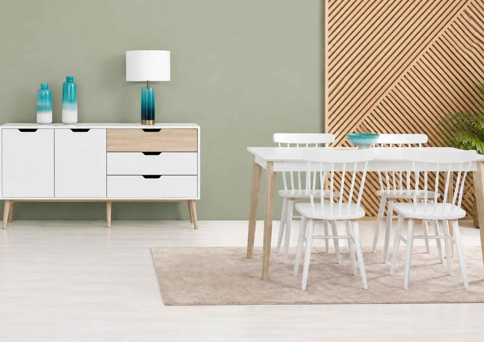 Sala de jantar com mesa e cadeiras brancas, aparador a condizer e painel de madeira ripada na parede